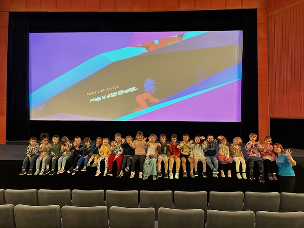 Náhledová fotka - Děti v kině sedící na podiu